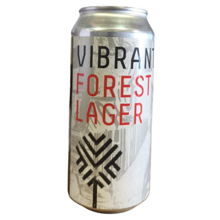Can of 'Vibrant Forest Lager' on a desk with a computer monitor in the background